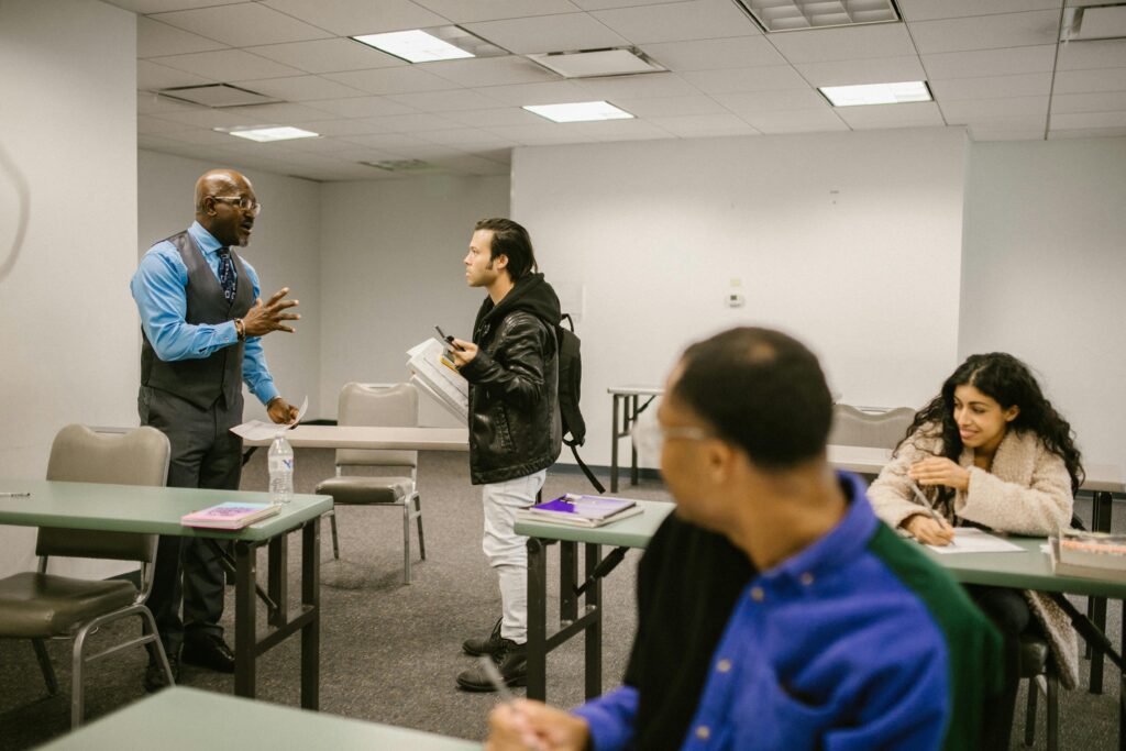 Teacher engaging with students in a diverse classroom setting.